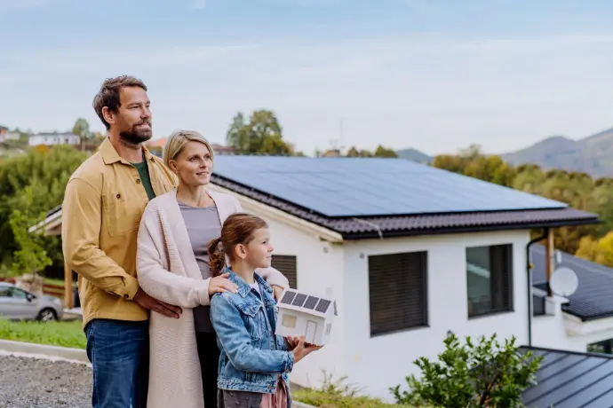 Une famille devant une maison solaire